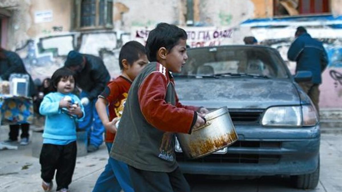 Distribución de alimentos 8Un niño griego recoge la comida entregada por una oenegé en el centro de Atenas.