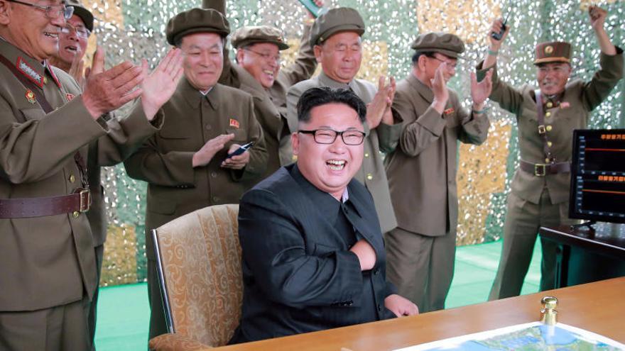 Kim Jong-un y miembros del Ejército celebran el lanzamiento de un misil.