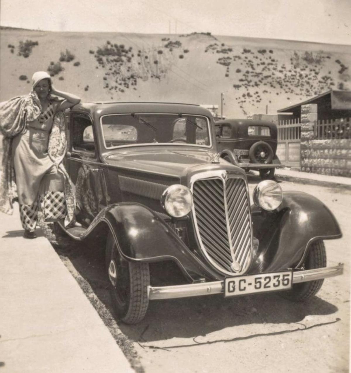Una vecina junto a un coche antigo en Guanarteme.