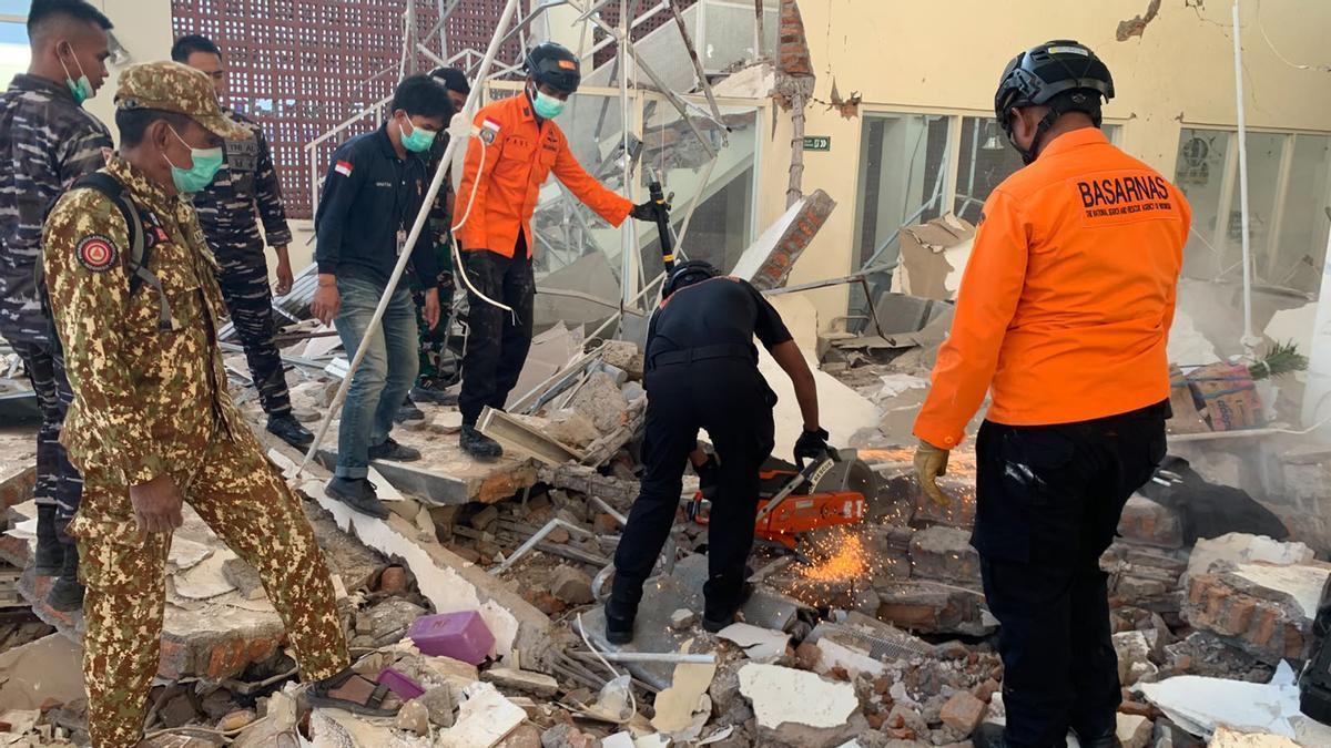 Personal de emergencias, entre los restos de un edificio de Maumere (Indonesia) que se ha venido abajo por el terremoto.