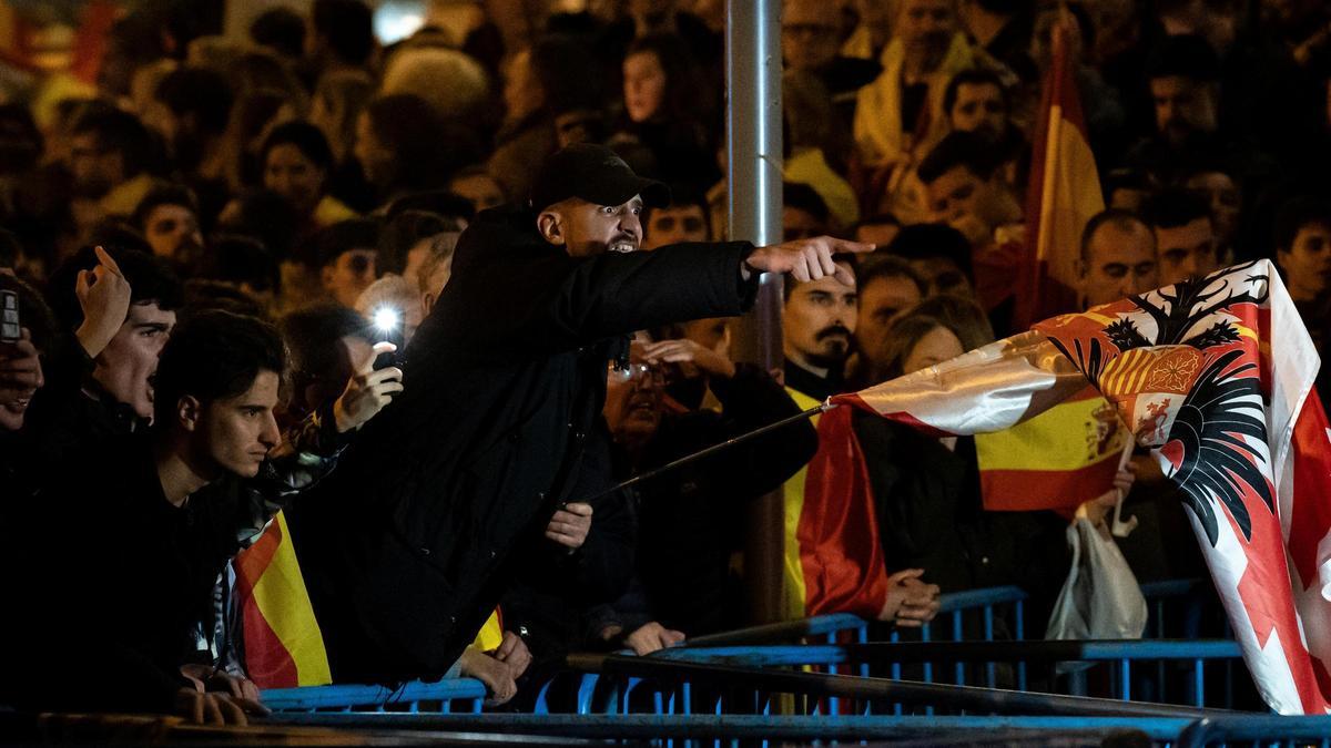 Decenas de manifestantes con banderas increpan a la policía, durante una manifestación contra la amnistía frente a la sede del PSOE en Ferraz.