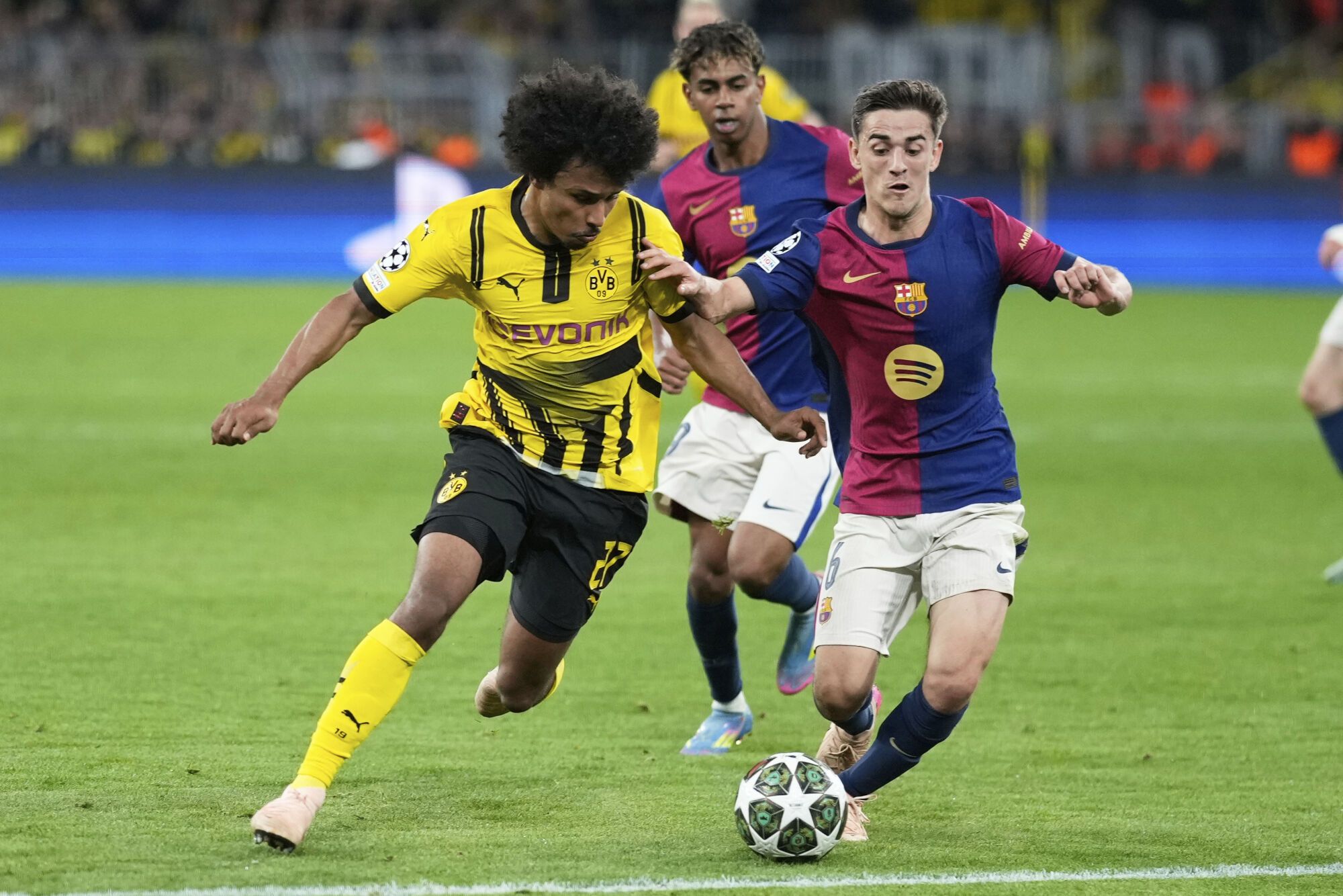 Barcelona's Gavi, right, challenges Dortmund's Karim Adeyemi during the Champions League quarterfinals second leg soccer match between Borussia Dortmund and Barcelona, at the Signa-Iduna Park in Dortmund, Germany, Tuesday, April 15, 2025. (AP Photo/Matthias Schrader)