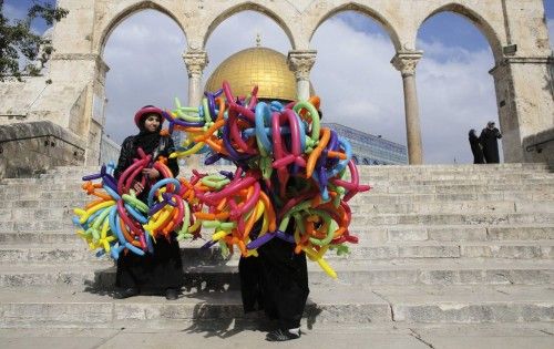 Palestinian school teachers hold balloons in front of the Dome of the Rock in Jerusalem's Old City