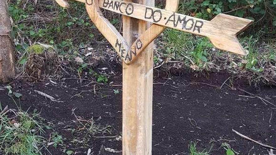 Dos amigos posan en el banco del amor de Meaño hasta el que llegaron gracias a las indicaciones en la carretera. // T.H.