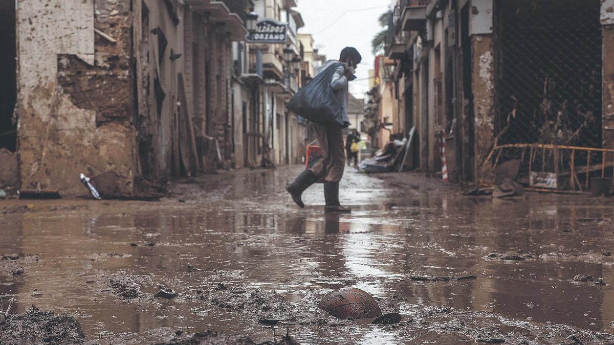 Un hombre se traslada por las calles inundadas de Paiporta días después de la ‘barrancada’ del Poyo.