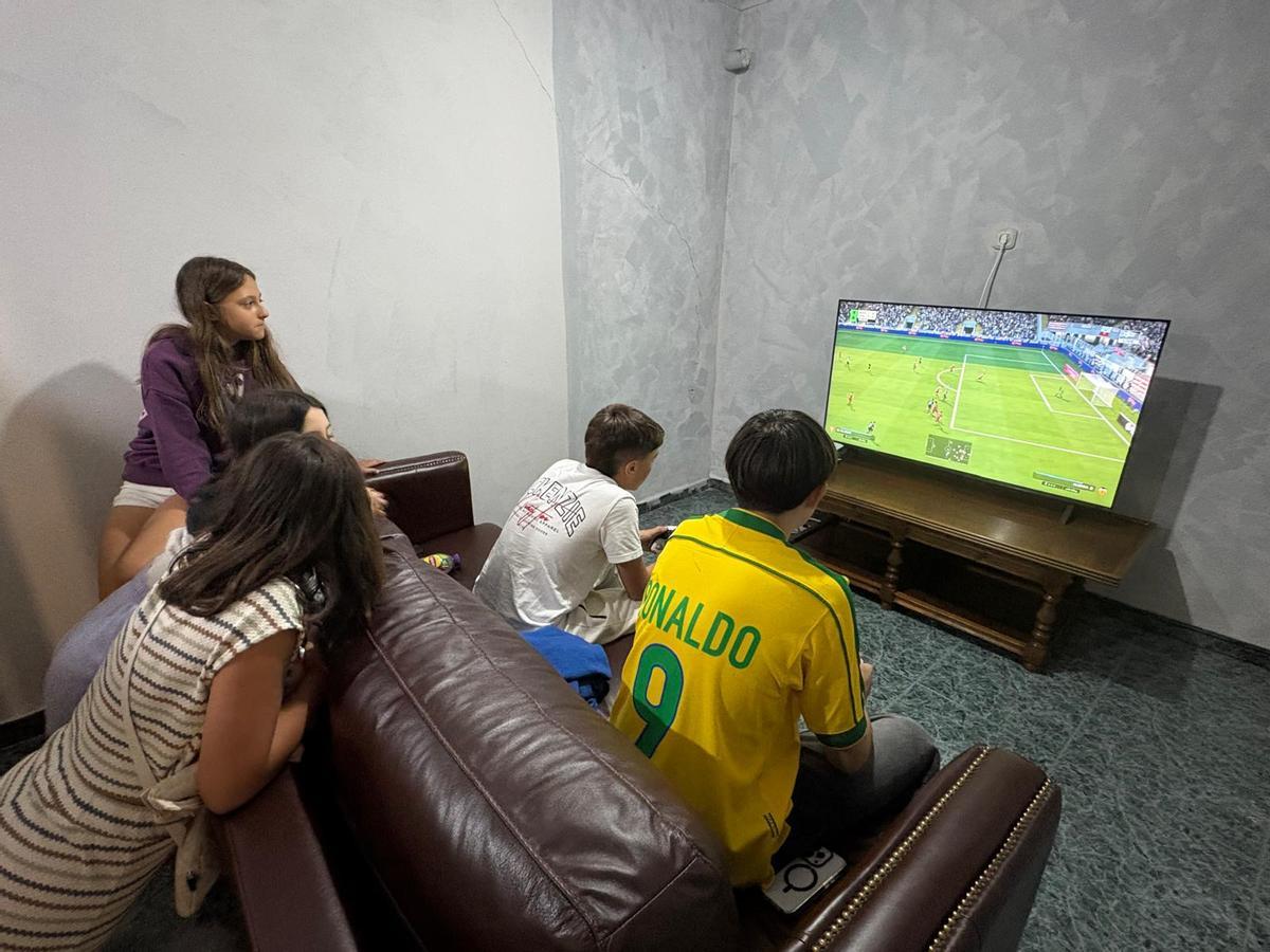 Jóvenes jugando con videojuegos en una segunda sala más pequeña.