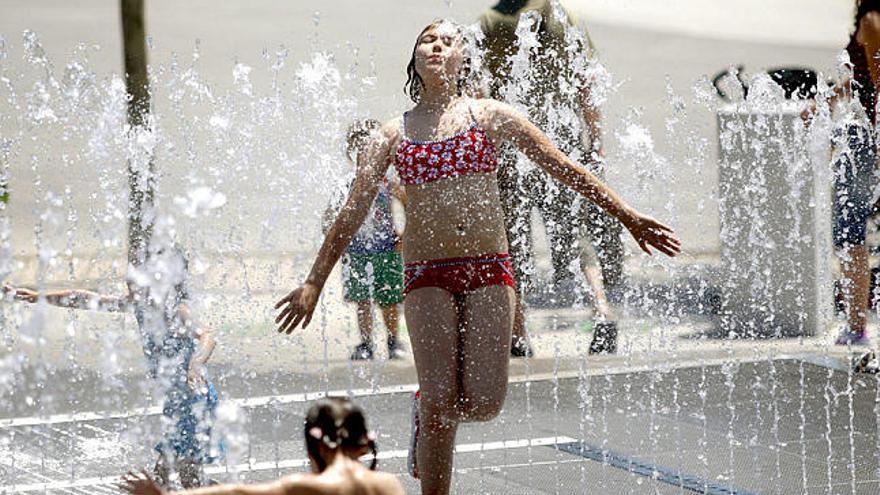 Una niña combate el calor en una fuente del recinto de la Exposición Internacional de Zaragoza.