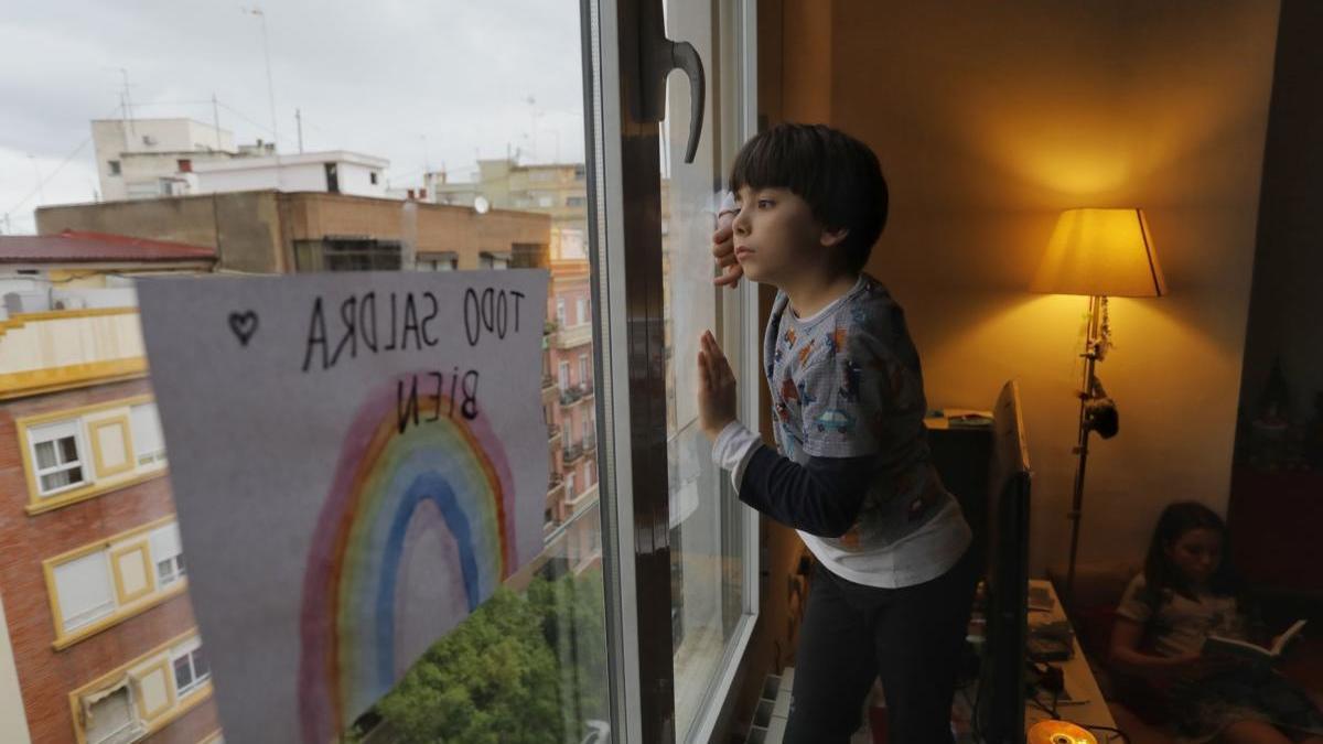 Un niño mira por la ventana durante la cuarentena.