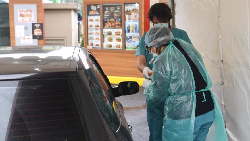 Técnicos realizan la toma de muestras a pacientes en sus coches, ayer, en A Coruña.