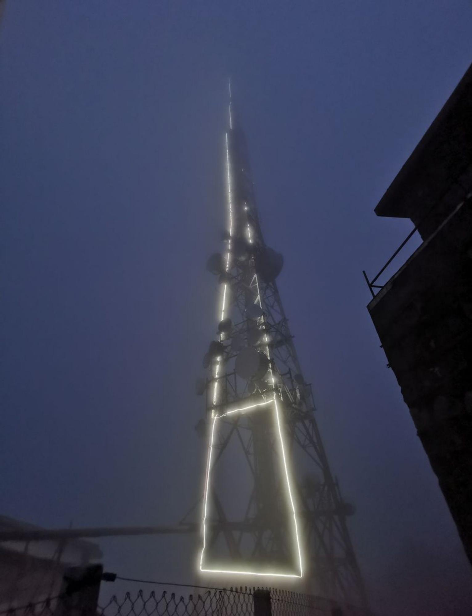 Una panorámica del centro emisor de Domaio con su torre y el edificio iluminados. 