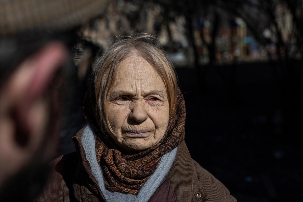 Una mujer en el exterior de un edificio residencial dañado por los bombardeos en Kiev.
