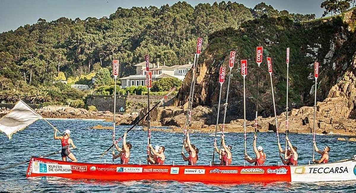 La tripulación de la “Maruxía” de Bueu alza sus remos en Perillo para celebrar su primera bandera. |  // LGT