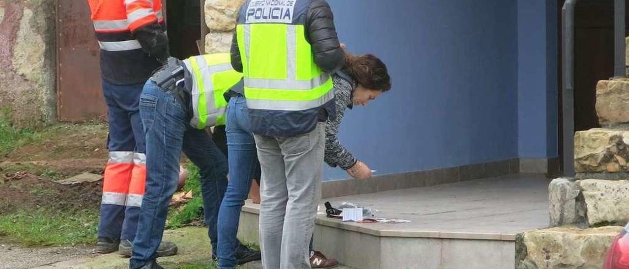 Agentes de la Policía examinan pruebas halladas en la casa de Berbes.