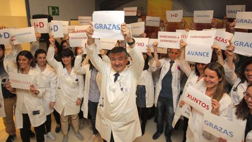 El doctor López y su equipo muestran carteles de agradecimiento.