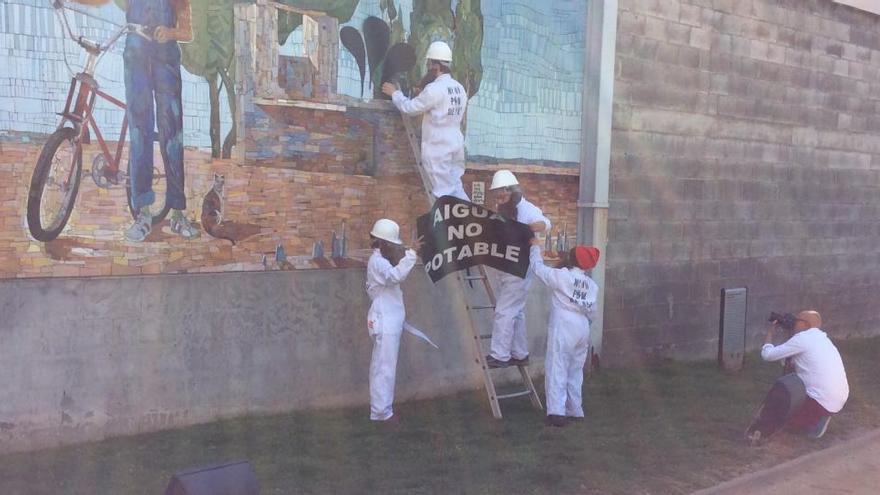 Activistes penjant el cartell al mural de Figueres