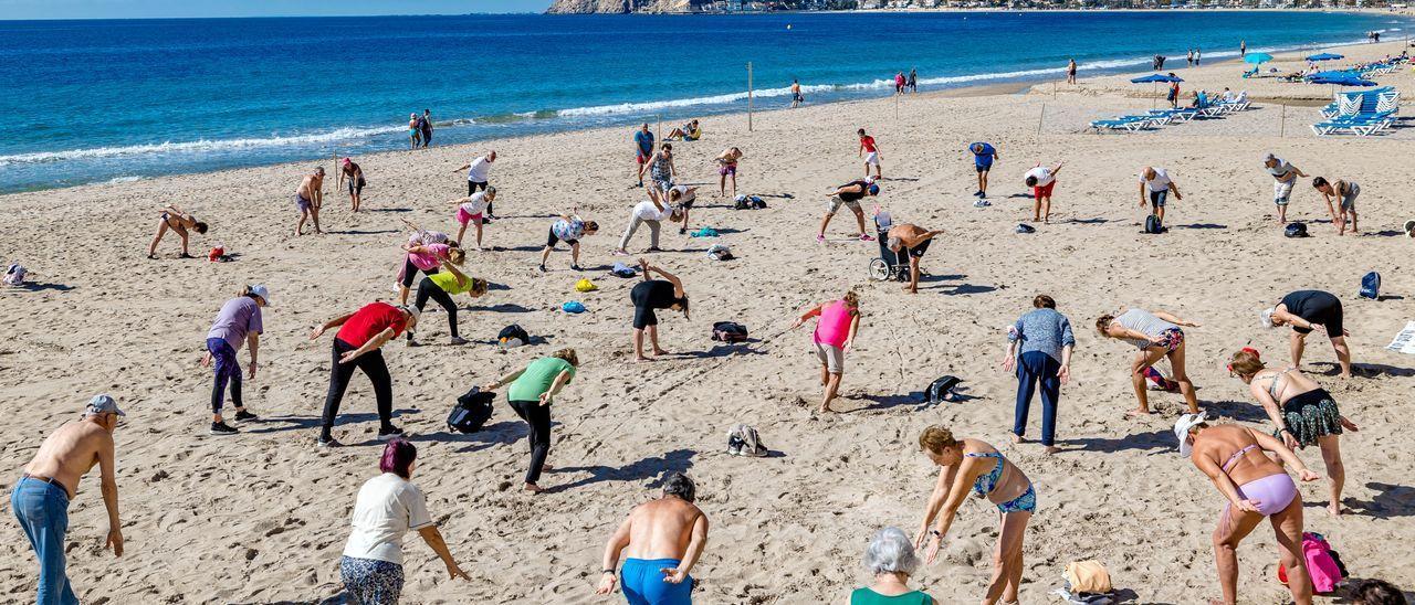 Jubilados del Imserso haciendo gimnasia en la playa de Poniente de Benidorm esta primavera.