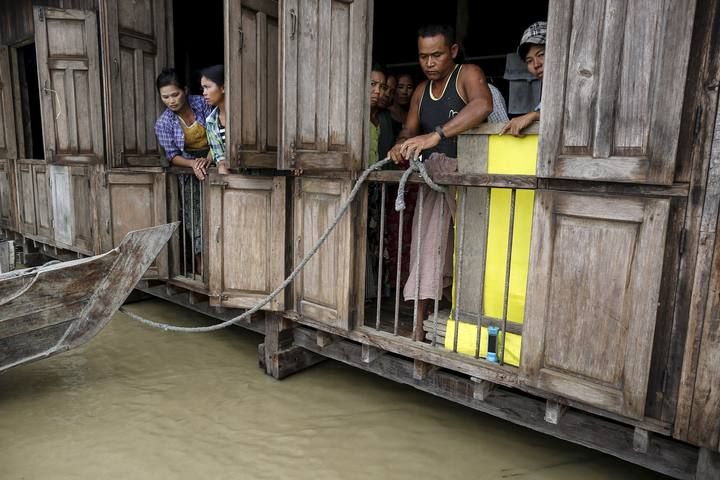 Flood victims stand in a monastery which is being used as a temporary refugee camp in a flooded village outside Zalun Township, Irrawaddy Delta