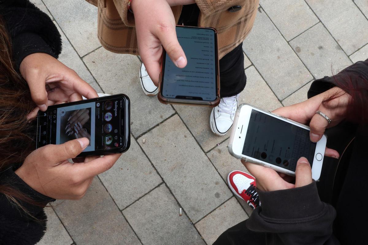 jovenes utilizando telefonos moviles