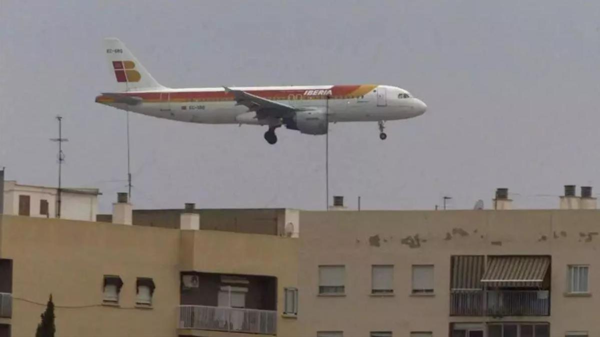 Imagen de un avión sobrevolando viviendas.