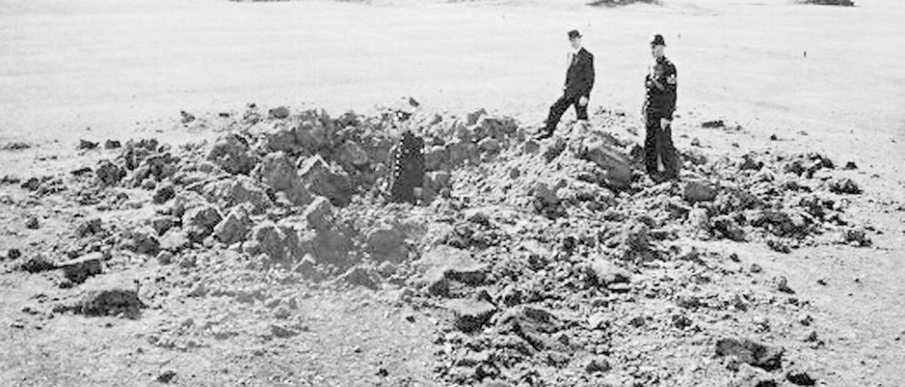 Varios policías inspeccionan uno de los cráteres abiertos en mitad del campo de Richmond.