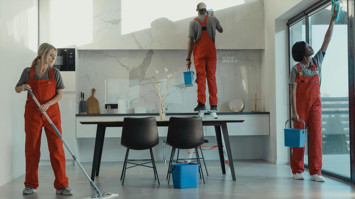 Varias personas limpian una casa.