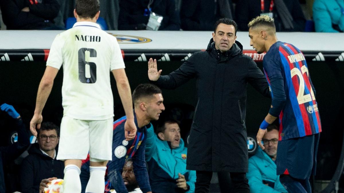 Xavi Hernández pidiendo calma en una acción del partido en el Bernabéu