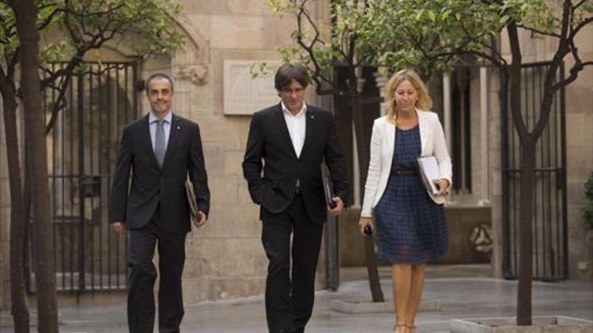 AVANZANDO Puigdemont (centro) y Munté se dirigen a la reunión del Govern.
