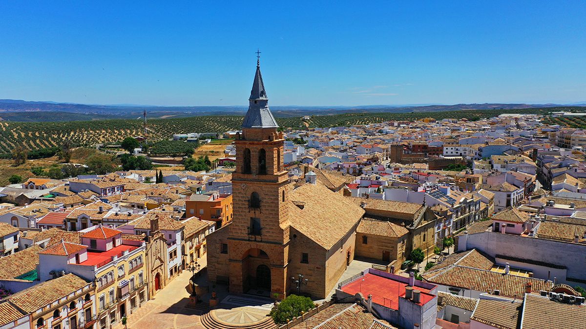 Vista aérea de Arjonilla con la iglesia de la Encarnación como protagonista, rodeada por el mar de olivos que define el paisaje del corazón andaluz