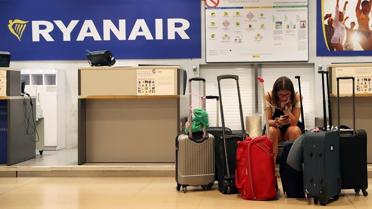 Una pasajera consulta su teléfono móvil en el aeropuerto de Madrid el primer día de la huelga de pilotos de Ryanair en varios países europeos, el 25 de julio del 2018