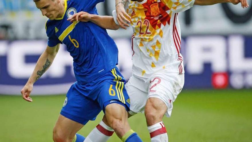 Nolito disputa un balón a Ognjen Vranjes durante el último España-Bosnia. // Efe