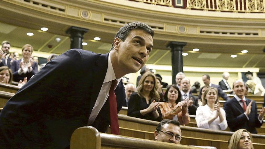 Pedro Sánchez se sienta durante el pleno de ayer en el Congreso de los Diputados ante los aplausos de su grupo. // Efe