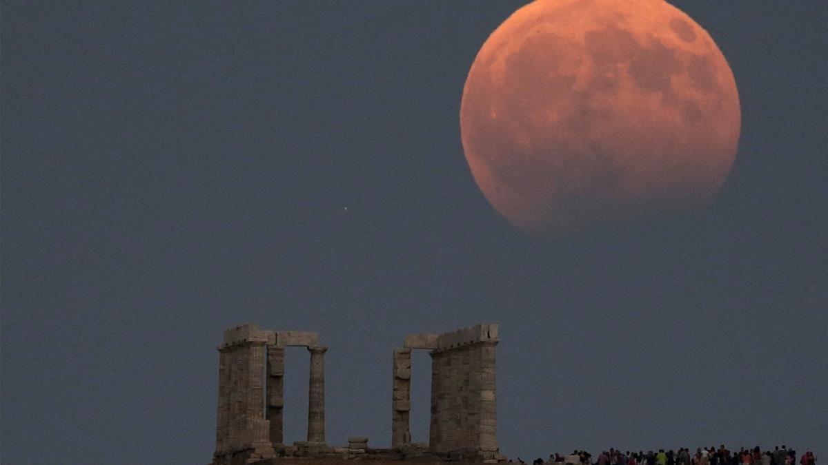 rjulve39594632 temple of poseidon is seen as a full moon is partially cover180718115640