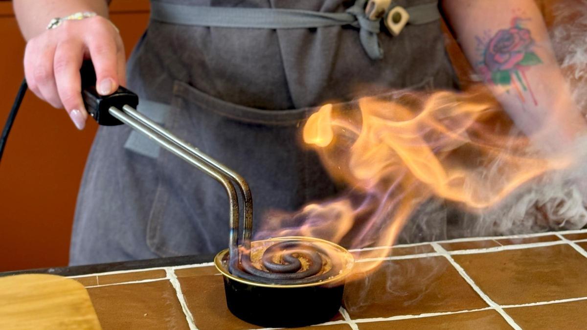 Momento en que se quema el azúcar de una crema catalana de Sucre Cremat.