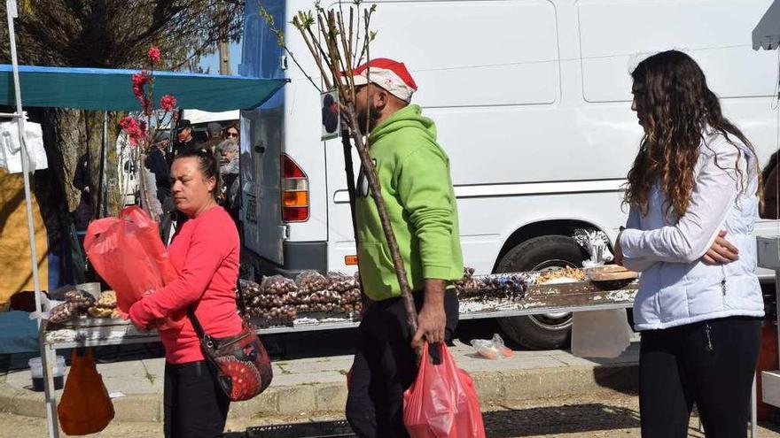 Los romeros pasean entre los puestos del mercadillo con sus compras.