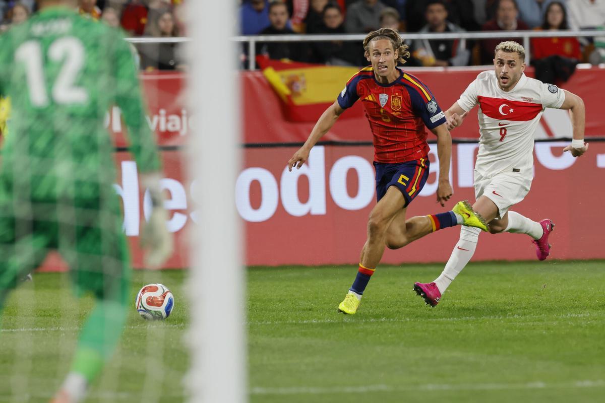 SEVILLA, 18/11/2025.- El centrocampista de la selección española, Marcos Llorente (i), se lleva el balón ante el centrocampista de Turquía, Baris Alper Yilmaz, durante el encuentro correspondiente a la fase de clasificación para el Mundial 2026 que disputan hoy martes España y Turquía en el estadio de La Cartuja, en Sevilla. EFE / José Manuel Vidal.