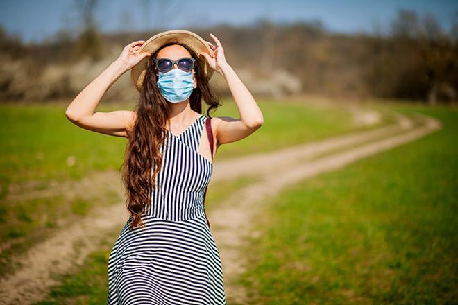 Mujer con gafas y mascarilla dando un paseo