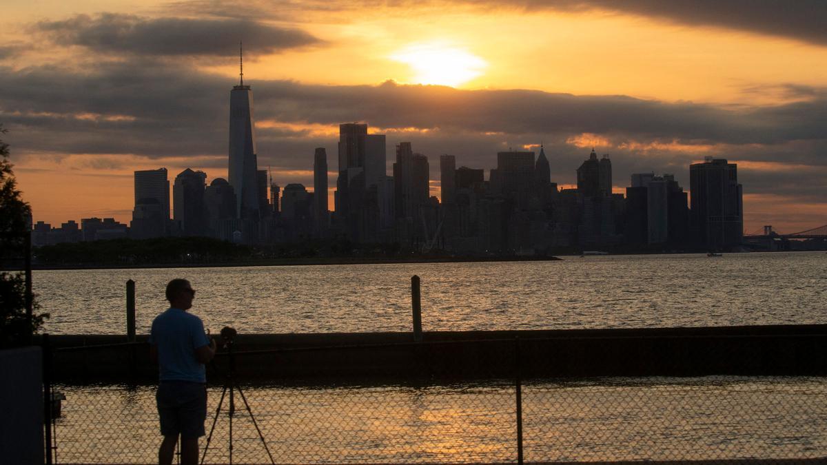 The New York skyline is seen as the Moon partially covers the sun during a partial solar eclipse on June 10, 2021 seen from Jersey City, New Jersey. - Northeast states in the U.S. will see a rare eclipsed sunrise, while in other parts of the Northern Hemisphere, this annular eclipse will be seen as a visible thin outer ring of the sun's disk that is not completely covered by the smaller dark disk of the moon, a so-called &quot;ring of fire&quot;. (Photo by Kena Betancur / AFP)