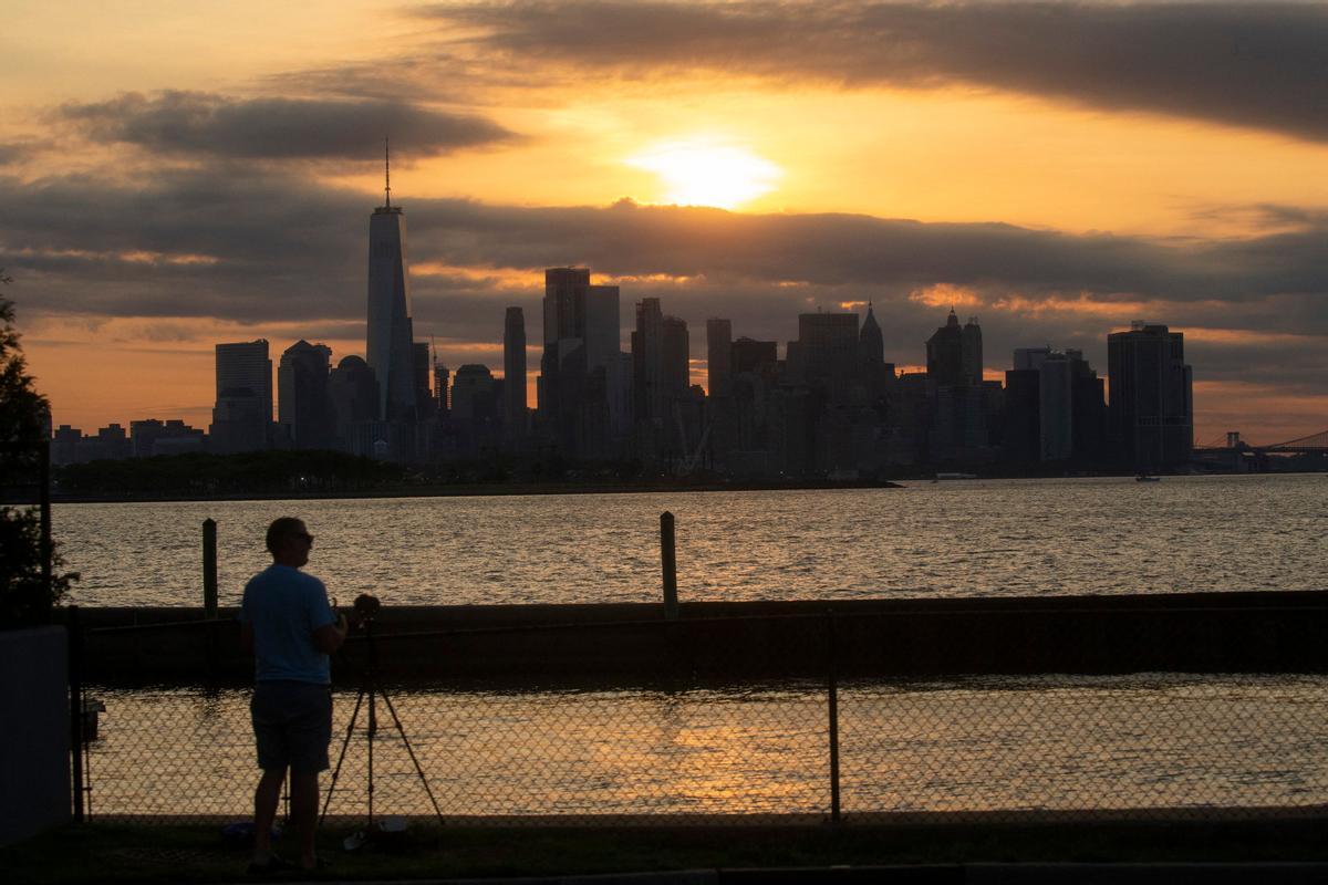 The New York skyline is seen as the Moon partially covers the sun during a partial solar eclipse on June 10, 2021 seen from Jersey City, New Jersey. - Northeast states in the U.S. will see a rare eclipsed sunrise, while in other parts of the Northern Hemisphere, this annular eclipse will be seen as a visible thin outer ring of the sun’s disk that is not completely covered by the smaller dark disk of the moon, a so-called ring of fire. (Photo by Kena Betancur / AFP)