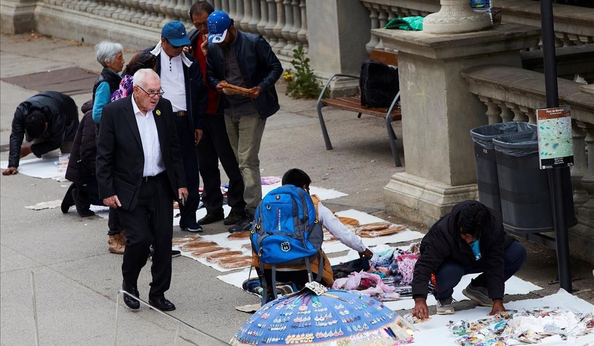 Ernest Maragall, candidato de ERC a la alcaldía de Barcelona, observa varios puestos de manteros tras la presentación de sus carteles de campaña en el mirador del Palau Nacional de Montjuïc.