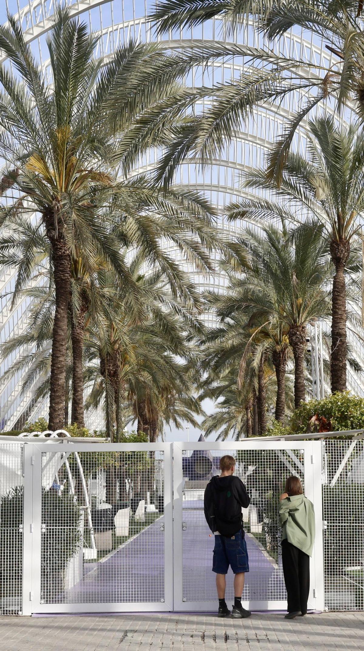 Una pareja de turistas en la puerta cerrada de l’Umbracle, la terraza nocturna de la Ciutat de les Arts i les Ciències.