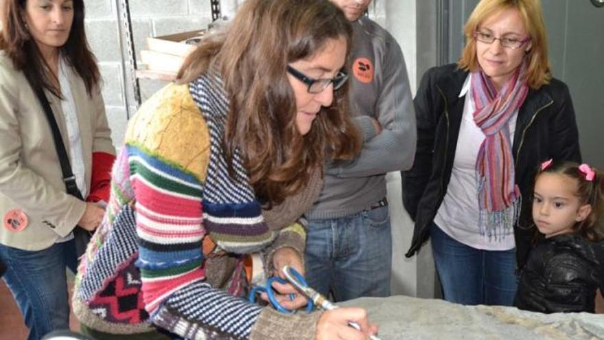 Laura Piñuela enseña a varios visitantes cómo se trabaja con la aguja percutora.