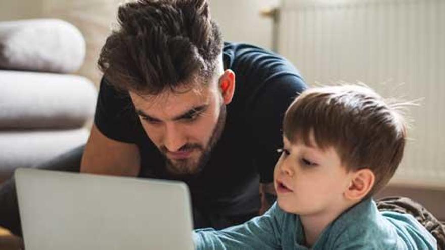 Un padre y su hijo, ante un portátil.