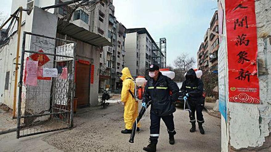 Un grup de treballadors desinfecta un complex residencial a Kaifeng, a la província xinesa de Henan