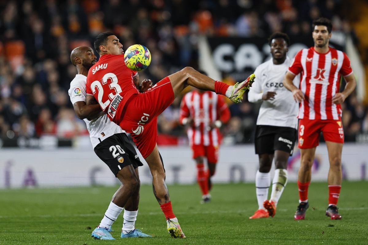 VALENCIA, 23/01/2023.- El defensa francés del Valencia CF Dimitri Foulquier (i) y el centrocampista del Almería Samu (2i), pelean un balón durante el partido de Liga en Primera División que Valencia CF y UD Almería disputan este lunes en el estadio de Mestalla. EFE/Biel Aliño