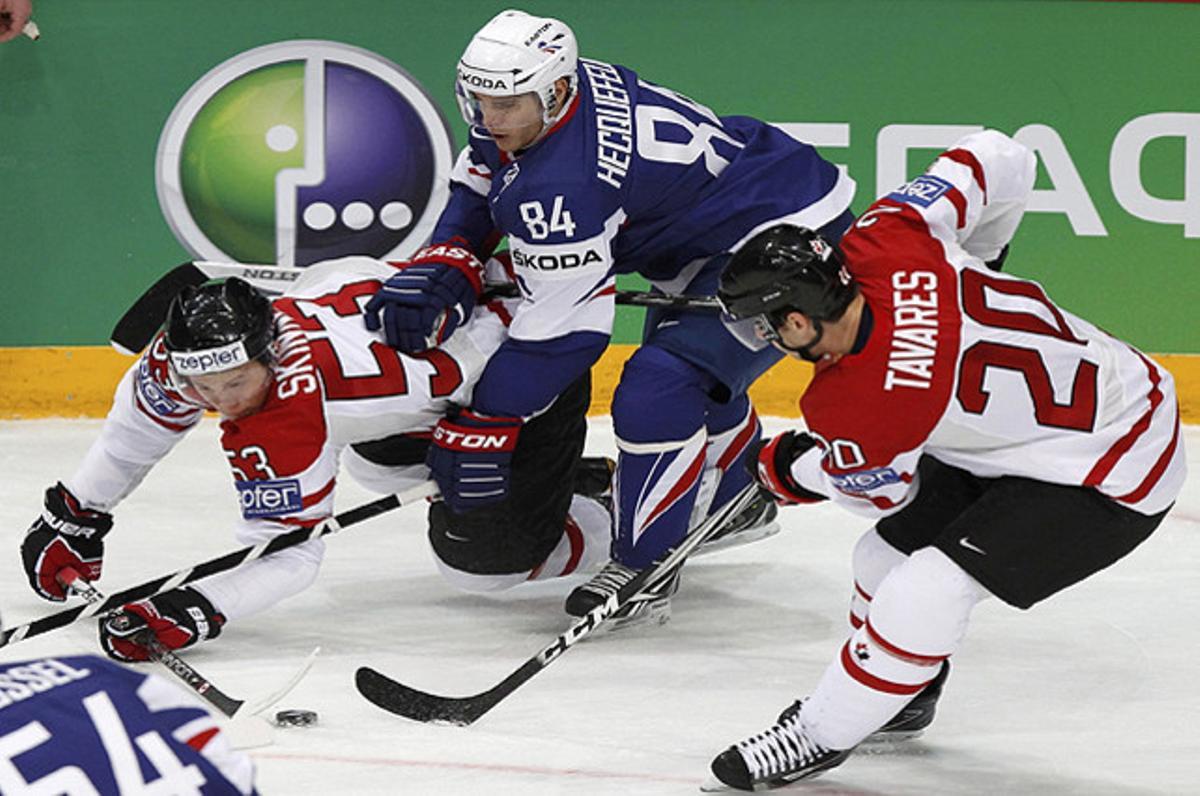 Els canadencs Jeff Skinner i Juan Tavares lluiten per la pastilla contra el francès Kevin Hecquefeuille (centre), durant un partit del mundial d’hoquei a Hèlsinki.