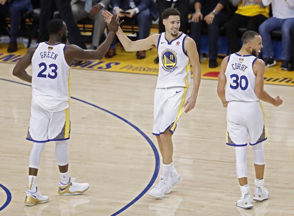LWS107. OAKLAND (EE.UU.), 31/05/2018.- Draymond Green (i), Klay Thompson (c) y Stephen Curry (d) celebran durante el primer partido de la final de la NBA entre Golden State Warriors y Cleveland Cavaliers, en Oakland, California (Estados Unidos) hoy, jueves 31 de mayo de 2018. EFE/JOHN G. MABANGLO /PROHIBIDO SU USO POR SHUTTERSTOCK