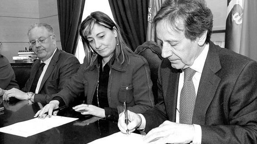 Villalba y Díaz firman los estatutos del consorcio del tren minero de Samuño, con el secretario municipal al fondo.