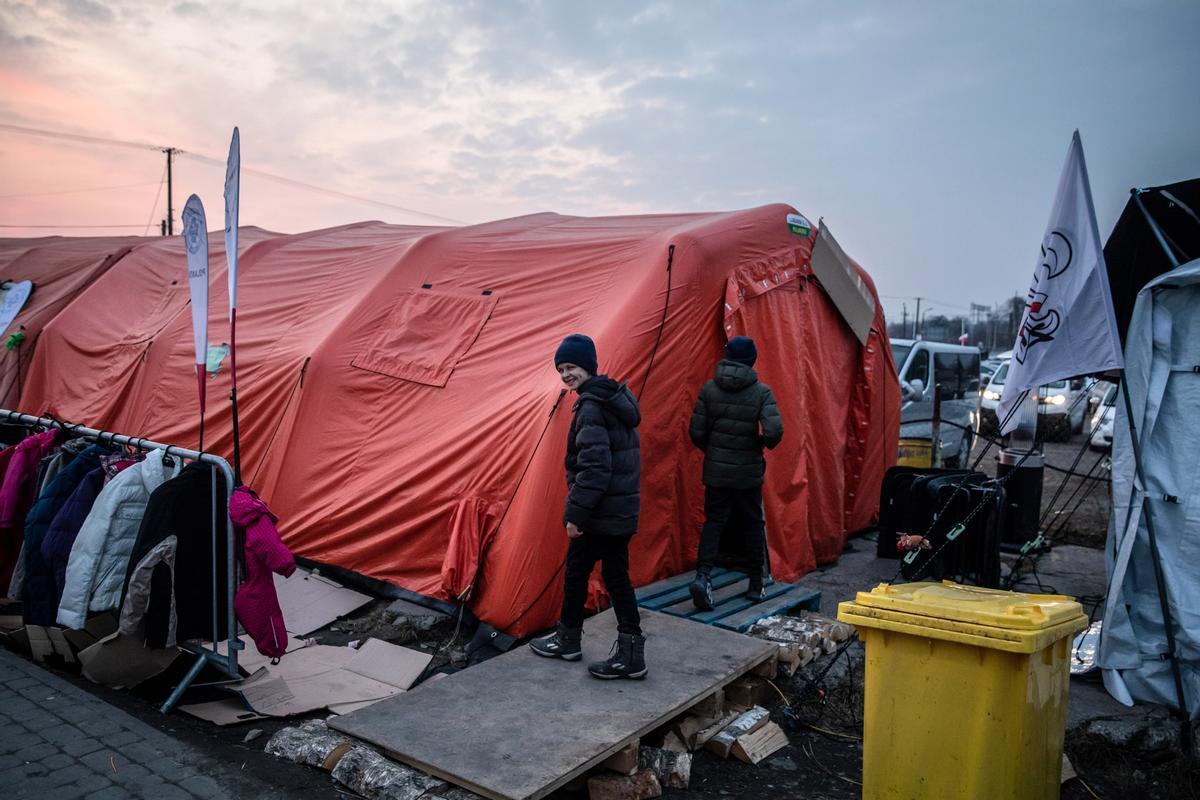 Niños procedentes de Ucrania se disponen a entrar en un refugio provisional construido en Medyka, en la frontera con Polonia.