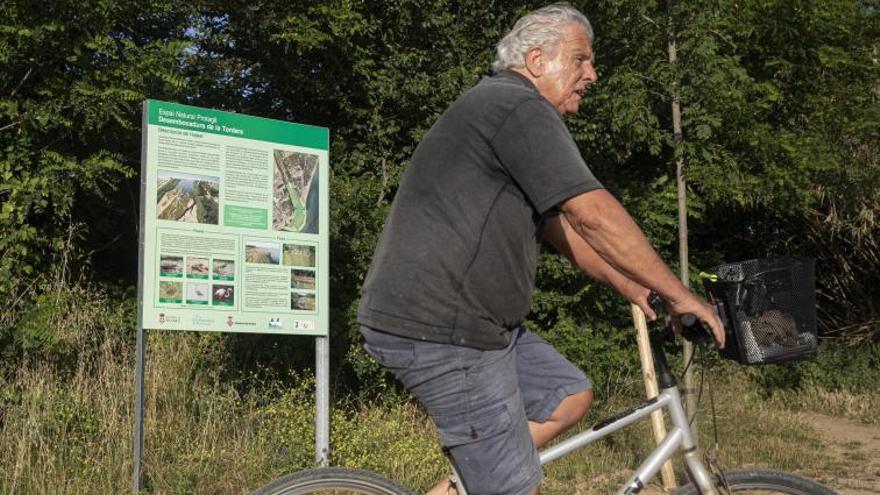 4 Un home passa en bicicleta just davant d’un dels cartells explicatius que s’han instal·lat al delta. F  | DAVID APARICIO  