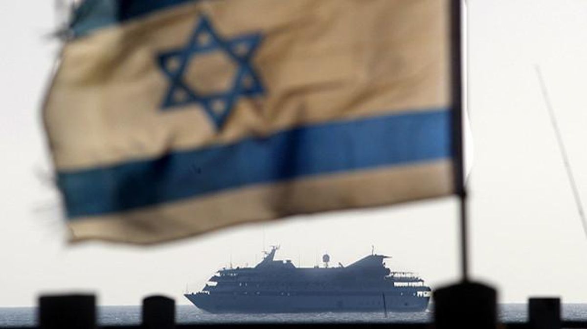 El vaixell Mavi Marmara, el més gran de la flotilla, darrere d’una bandera que oneja des d’un vaixell de guerra israeliana.